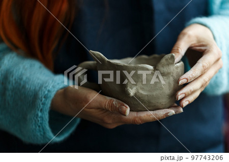 Woman potter in apron molding clay cup.Hands of professional ceramist create pottery crockery at workplace. Craftsmanship hobby.Small business with ceramics master classes education or handmade shop. 97743206