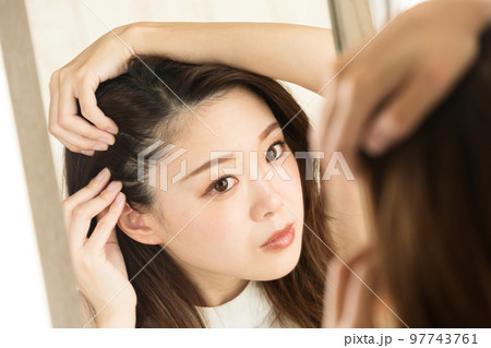 鏡で頭皮を見る女性 97743761