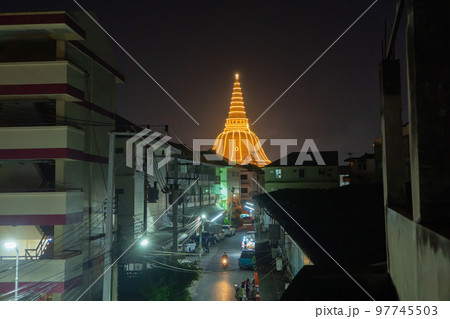 Phra Pathommachedi temple at night. The golden buddhist pagoda with residential houses, urban city of Nakorn Pathom district, Thailand. Holy Thai architecture. 97745503