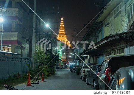 Phra Pathommachedi temple at night. The golden buddhist pagoda with residential houses, urban city of Nakorn Pathom district, Thailand. Holy Thai architecture. 97745504