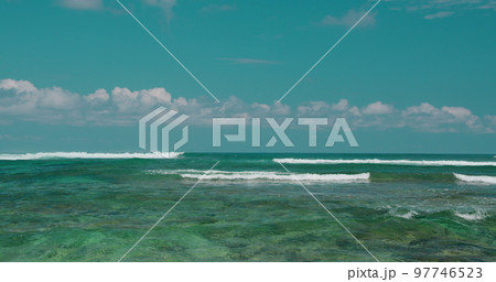 Azure pure ocean sea blue cloudy sky horizon early in the morning sunrise. Tropical Green Bowl Beach with foaming waves. Go everywhere travel concept. Azure pure ocean sea blue cloudy sky horizon early in the morning sunrise. Tropical Green Bowl Beach with foaming waves. Go everywhere travel concept. 97746523