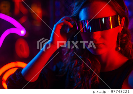 Caucasian woman in sunglasses posing in fog in neon studio. 97748221