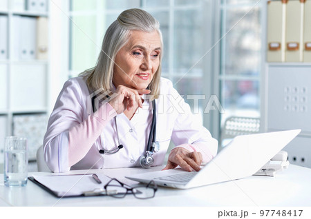 old female doctor working at her cabinet 97748417