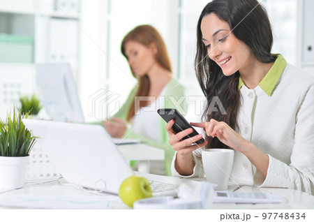 Two young businesswomen working at modern office Two young businesswomen working at modern office 97748434