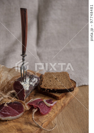 Close-up piece of jamon on fork, light appetizer, homemade food, selective focus 97748481