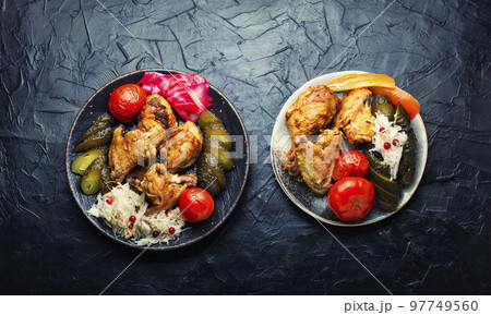 Tasty baked chicken and pickles. 97749560