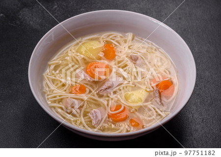 Delicious soup with noodles, chicken and carrots with spices and herbs Delicious soup with noodles, chicken and carrots with spices and herbs 97751182