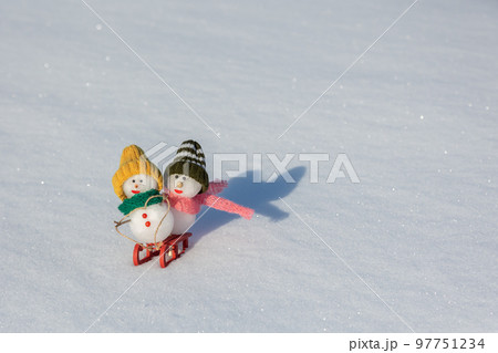 ソリ遊びをする雪だるまたち 97751234