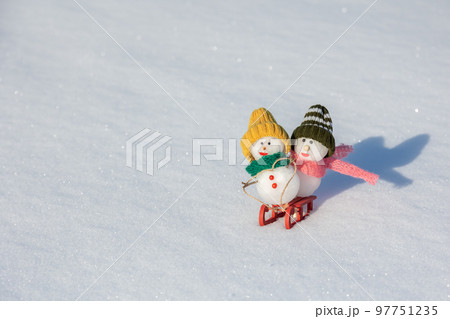 ソリ遊びをする雪だるまたち 97751235