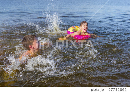 Happy children playing on the beach with splashing water. The concept of summer holidays 97752062
