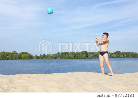 A boy playing Beach Volleyball. Sports games for children in the open air. Sports lifestyle. Ball games A boy playing Beach Volleyball. Sports games for children in the open air. Sports lifestyle. Ball games 97752131