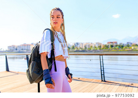 Protective skate safety concept , woman with equipment in beach and mountain background on a summer day Protective skate safety concept , woman with equipment in beach and mountain background on a summer day 97753092