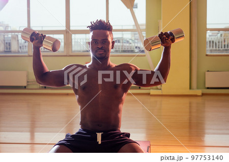 afro holding dumbbells workout for abc press and hands in gym windows background afro holding dumbbells workout for abc press and hands in gym windows background 97753140