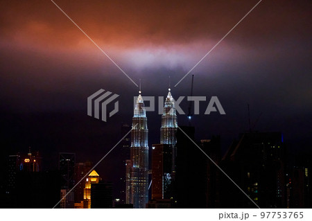 The night landscape of downtown Kuala Lumpur. View of the famous petronas oil company towers. The lighting of the buildings illuminates the clouds The night landscape of downtown Kuala Lumpur. View of the famous petronas oil company towers. The lighting of the buildings illuminates the clouds 97753765