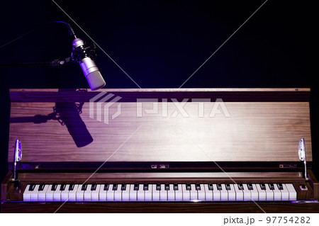condenser microphone over classical vintage piano on black. music background or piano recording concept condenser microphone over classical vintage piano on black. music background or piano recording concept 97754282