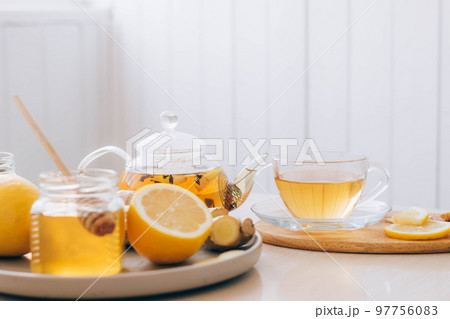Hot drink tea from ginger root lemon honey for cold treatment and prevention. Health and alternative medicine concept Hot drink tea from ginger root lemon honey for cold treatment and prevention. Health and alternative medicine concept 97756083