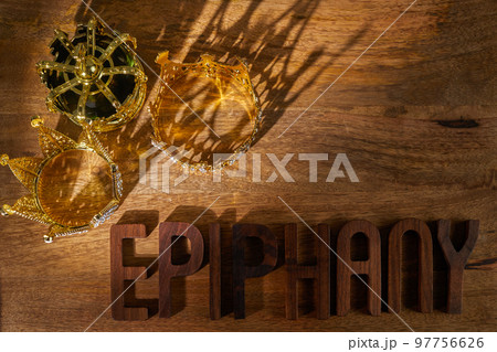 Happy Epiphany day. Three gold crowns on wooden background, symbol of Tres Reyes Magos, Three Wise Men.  97756626