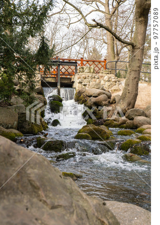 Waterfall cascade in Olivia public park Gdansk Poland. River waterfall falls from cliff and trees. Tourist attraction with small waterfall and clear water Waterfall cascade in Olivia public park Gdansk Poland. River waterfall falls from cliff and trees. Tourist attraction with small waterfall and clear water 97757089