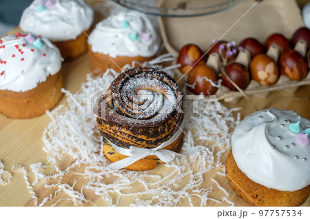 Easter cake kraffin with poppy seeds is on the table near the red eggs 97757534