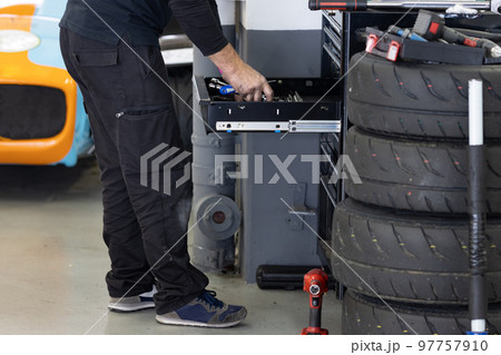 A man car mechanic takes tools out of a drawer 97757910