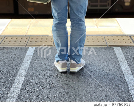 駅のホームに立つ人の足元 97760915