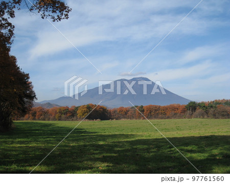 晩秋の牧場からみえる紅葉の森と少し冠雪した岩手山 晩秋の牧場からみえる紅葉の森と少し冠雪した岩手山 97761560