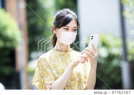 スマホ　若い女性　検索　調べる　マスク　歩く 97762167