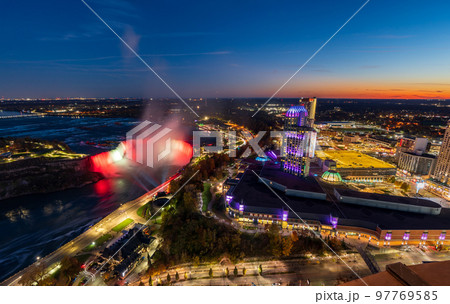 Aerial view of Horseshoe Falls in twilight time. Niagara Falls City downtown illumination. Stunning landscape at night. Aerial view of Horseshoe Falls in twilight time. Niagara Falls City downtown illumination. Stunning landscape at night. 97769585