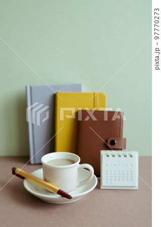 Diary notebook, calendar, pen, cup of coffee on desk. mint wall background. workspace 97770273