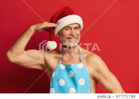 Honest Grandfather Posing Studio. Bearded Man In Santa Hat And Apron Honest Grandfather Posing Studio. Bearded Man In Santa Hat And Apron 97771788