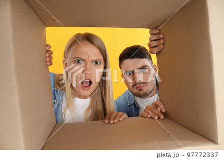 Concept of delivery, young man and woman look in to box 97772337