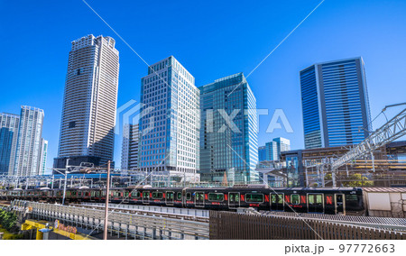 日本の東京都市景観　浜松町駅を発車した黒い山手線(内回り）や超高層ビル群などを望む 97772663