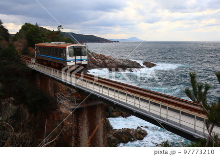 日本海をバックに青浦鉄橋を渡る山陰本線の列車 97773210