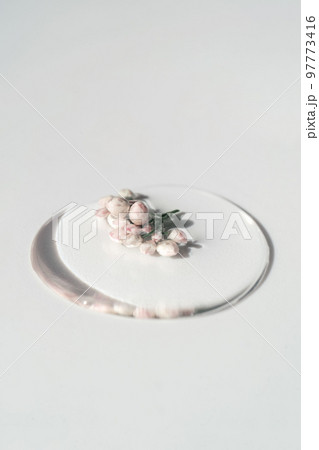A drop of cosmetic gel with flower on a white background. 97773416