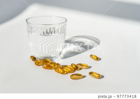 Oil filled capsules on the white background 97773418