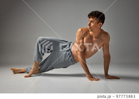 Sportive lifestyle. Mature handsome man posing shirtless in pants over grey studio background. Muscular, relief body aesthetics. Men's health and beauty Sportive lifestyle. Mature handsome man posing shirtless in pants over grey studio background. Muscular, relief body aesthetics. Men's health and beauty 97773863