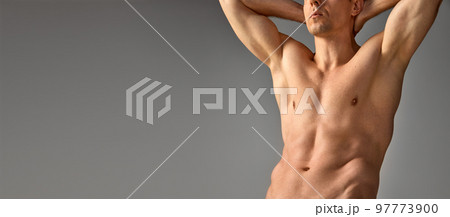 Cropped photo of muscular, relief male body over grey studio background. Man posing shirtless. Banner. Men's health and beauty Cropped photo of muscular, relief male body over grey studio background. Man posing shirtless. Banner. Men's health and beauty 97773900