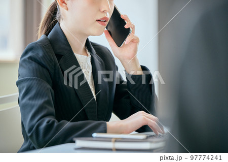 デスクで電話をする若い女性 97774241