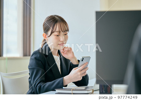 デスクで電話をする若い女性 97774249