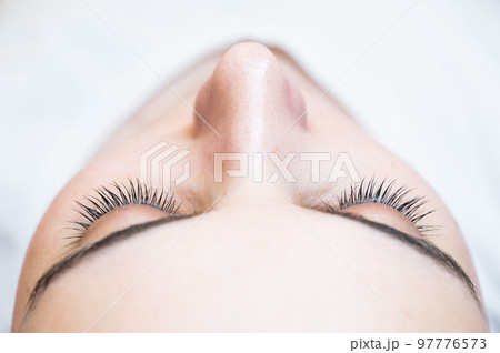 Close-up of a caucasian woman after eyelash lamination procedure. Close-up of a caucasian woman after eyelash lamination procedure. 97776573