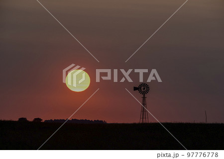 Windmill in countryside at sunset, Pampas, Patagonia,Argentina. 97776778