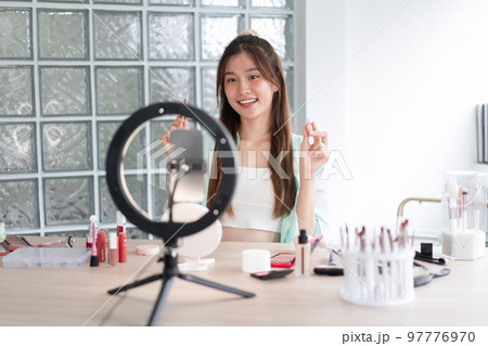 Beauty blogger concept, Young woman show concealer to introducing product and record video for Vlog Beauty blogger concept, Young woman show concealer to introducing product and record video for Vlog 97776970