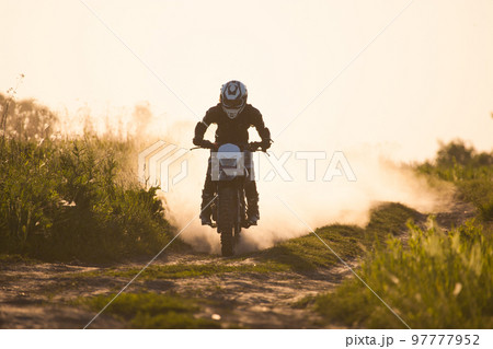 motorcyclist at sunset riding on the road motorcyclist at sunset riding on the road 97777952