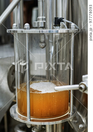 Close-up of tank with freshly brewed beer in modern brewery Close-up of tank with freshly brewed beer in modern brewery 97778093