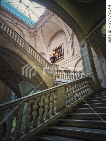 Louvre Palace architectural details of a hall with stone staircase, ornate railings and glowing vintage lamps, Paris, France Louvre Palace architectural details of a hall with stone staircase, ornate railings and glowing vintage lamps, Paris, France 97778144