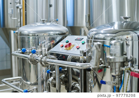 Horizontal image of storage tanks for brewing alcoholic beverages with control panel in factory 97778208