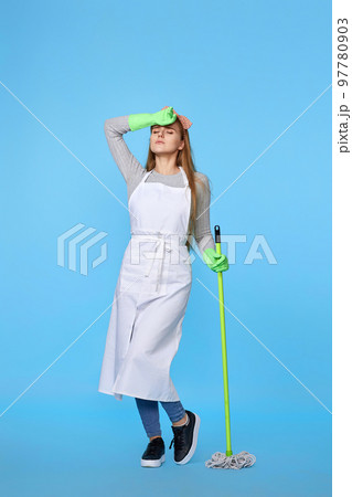 woman in rubber gloves and cleaner apron washing floor with mop 97780903