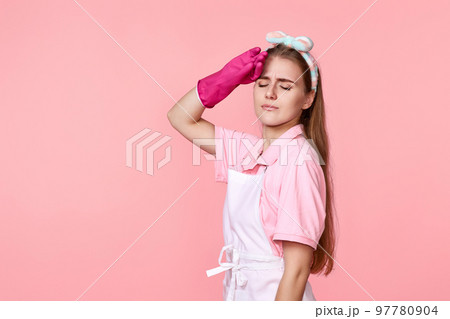 tired woman in gloves and cleaner apron 97780904