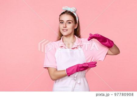 woman in rubber gloves and cleaner apron showing measure symbol gesture 97780908