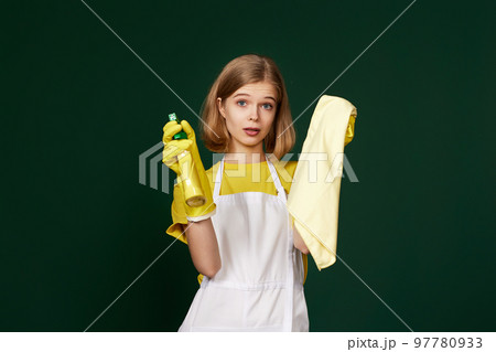 frowning woman cleaner apron with cleaning rag and detergent sprayer 97780933